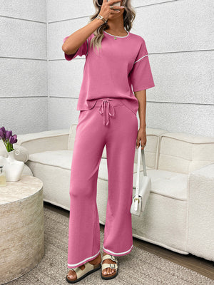 Fuchsia pink loungewear set with crew neck top and drawstring pants, featuring contrast piping detail.