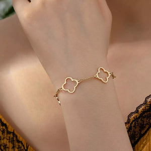 Gold four leaf clover bracelet with dainty chain detail.