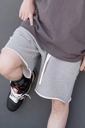 Gray jogger shorts with raw edge hem and white drawstring