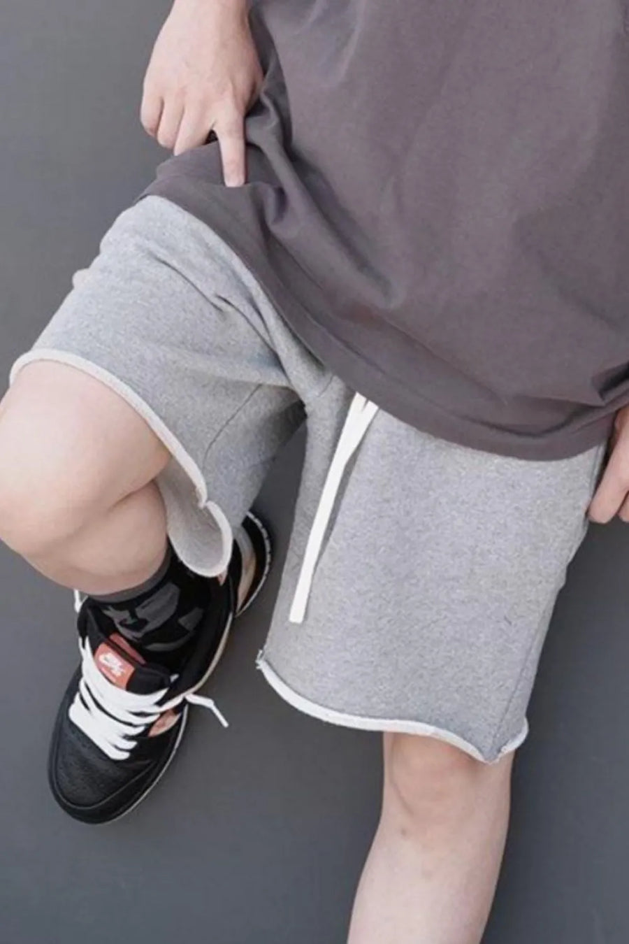 Gray jogger shorts with raw edge hem and white drawstring