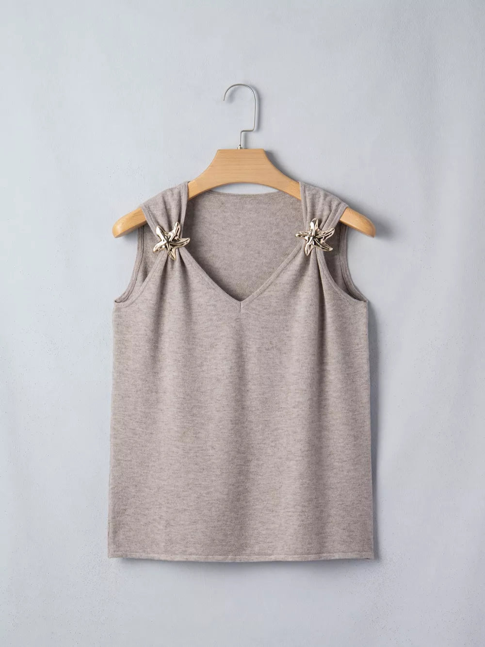 Light grey acrylic V-neck knit vest with star embellishments on shoulders.