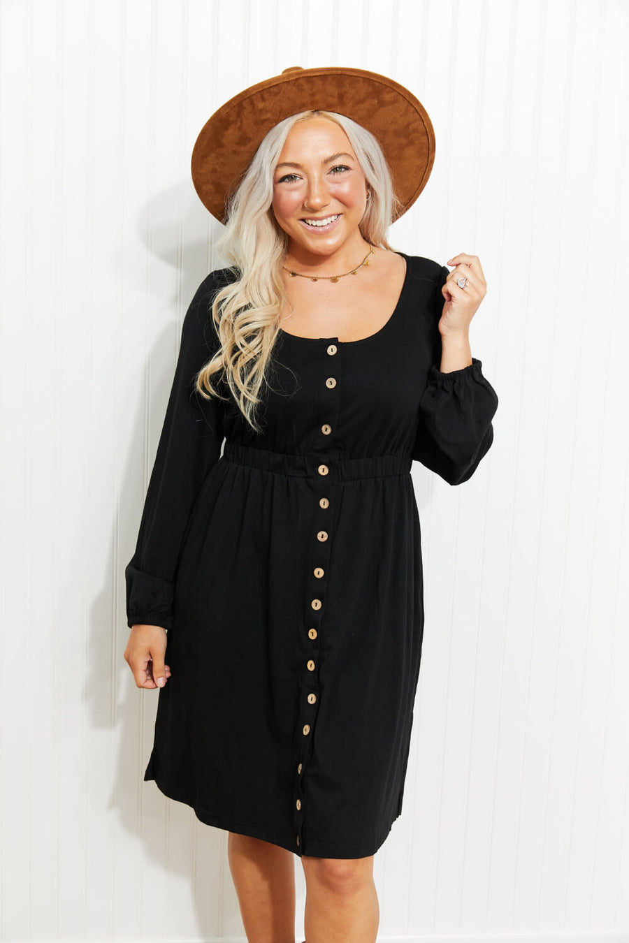Black button-down empire waist mini dress with long sleeves and scoop neck