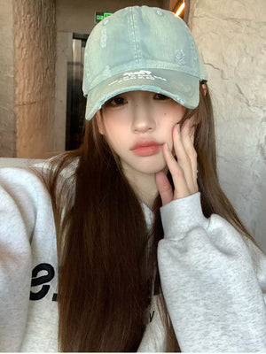 Distressed baseball hat in dirty blue cotton with embroidery and distressed details.