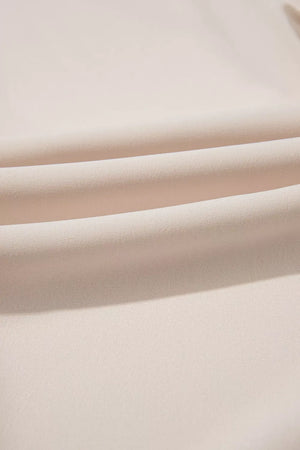 Elegant V-neck polyester blouse in a light beige, showing fabric texture and soft folds.