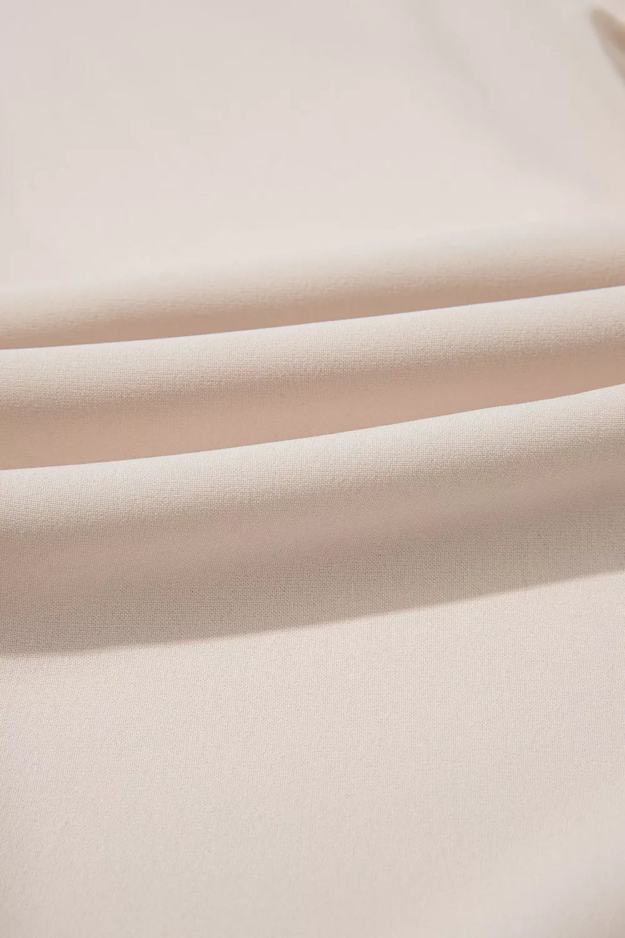 Elegant V-neck polyester blouse in a light beige, showing fabric texture and soft folds.