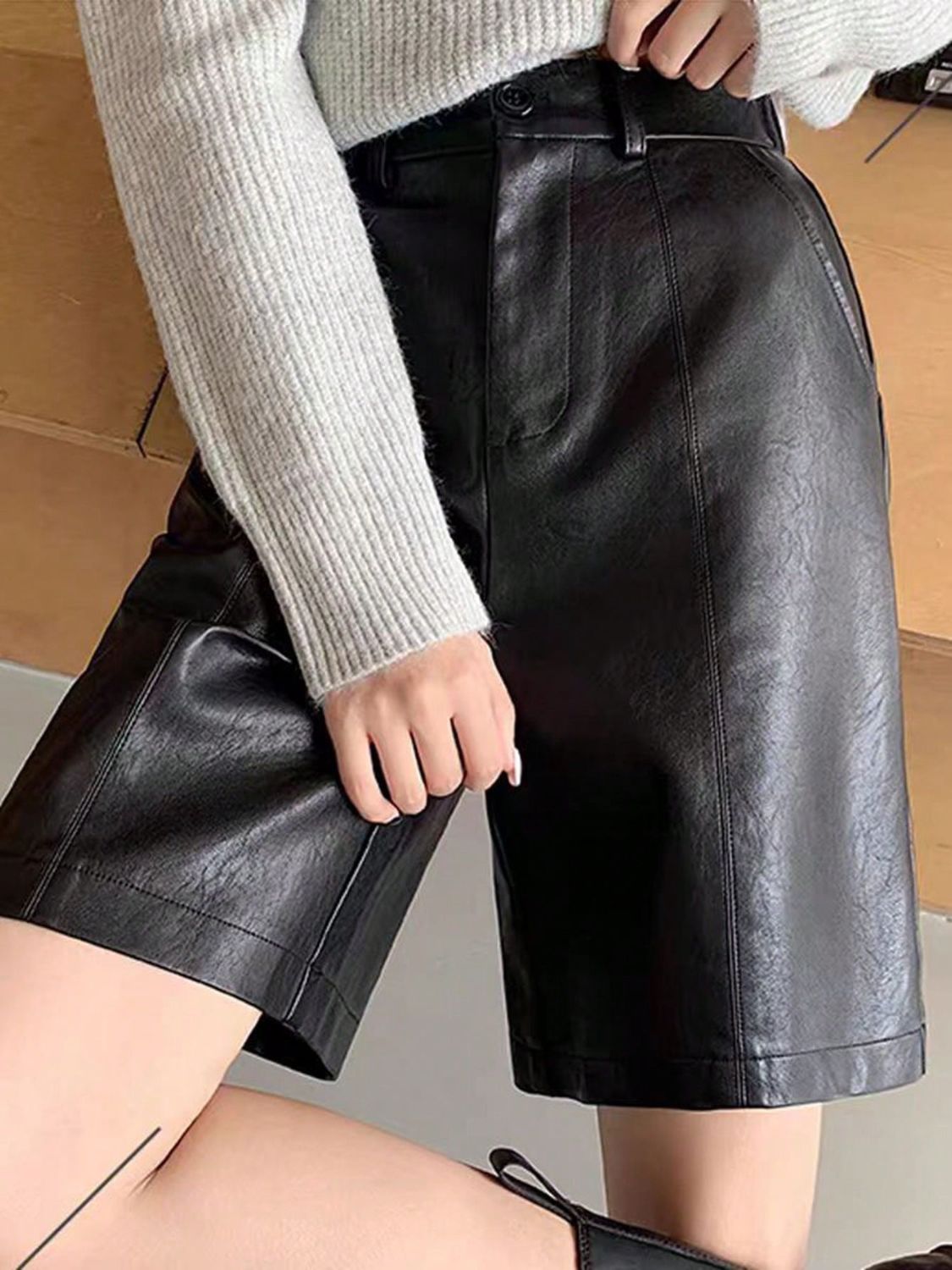 Black vegan leather Bermuda shorts with button closure and tailored fit