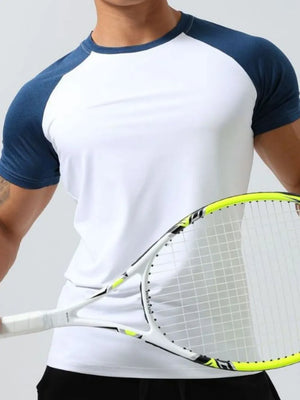 White raglan sleeve performance tee with navy sleeves and collar, worn by a man holding a tennis racket.
