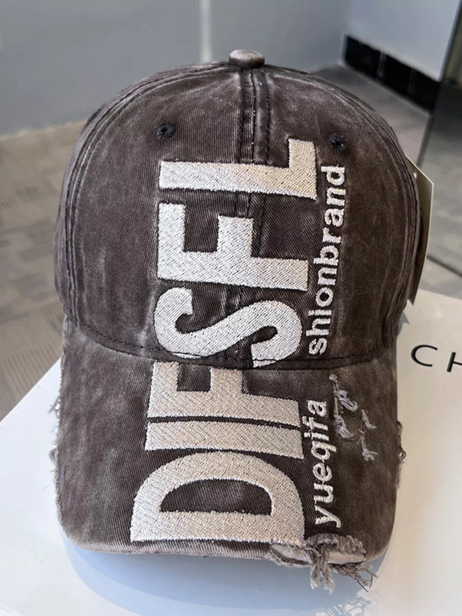 Distressed baseball cap in coffee color with white embroidered text and frayed edges.