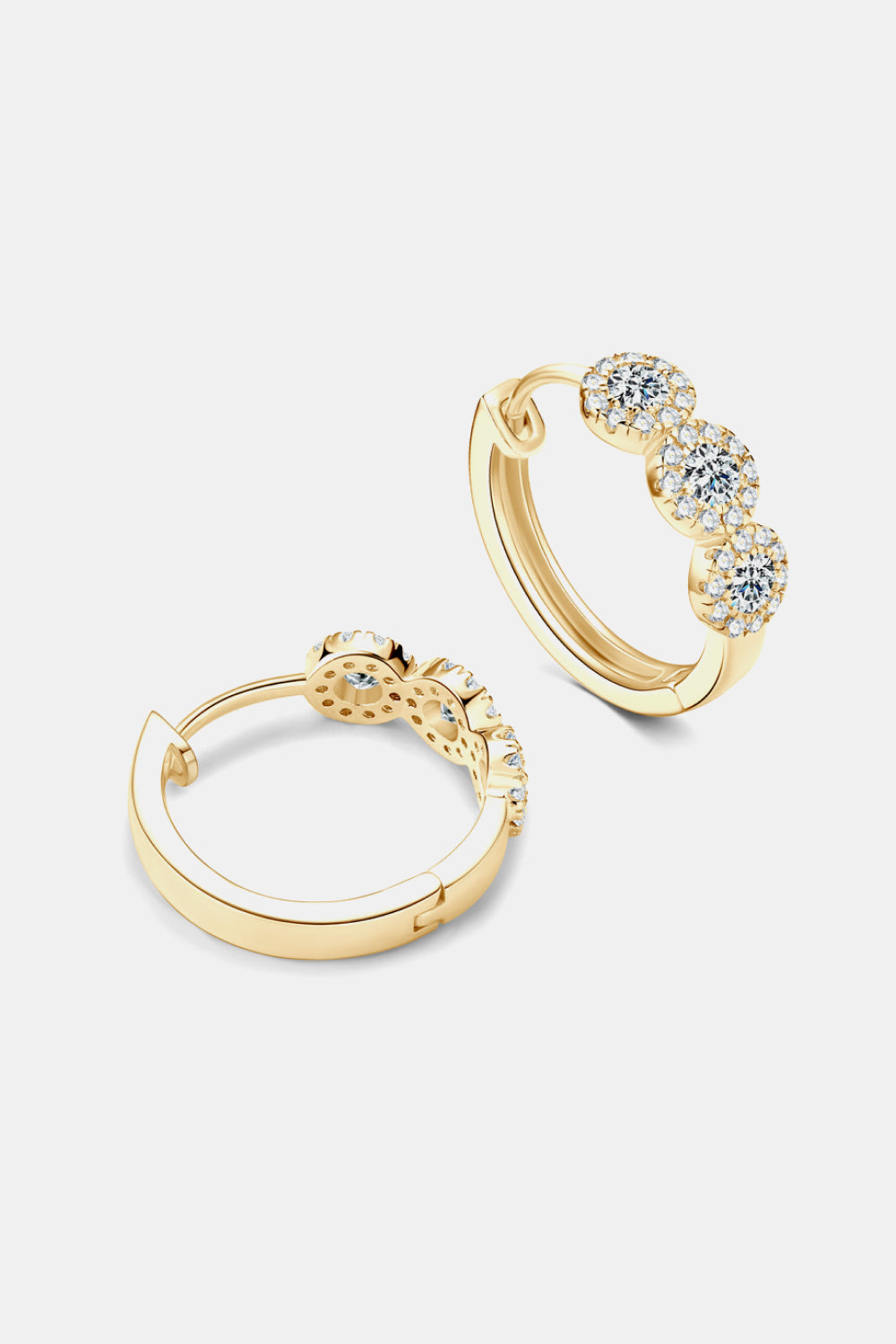 Gold triple cluster diamond huggie hoop earrings with sparkling stones.
