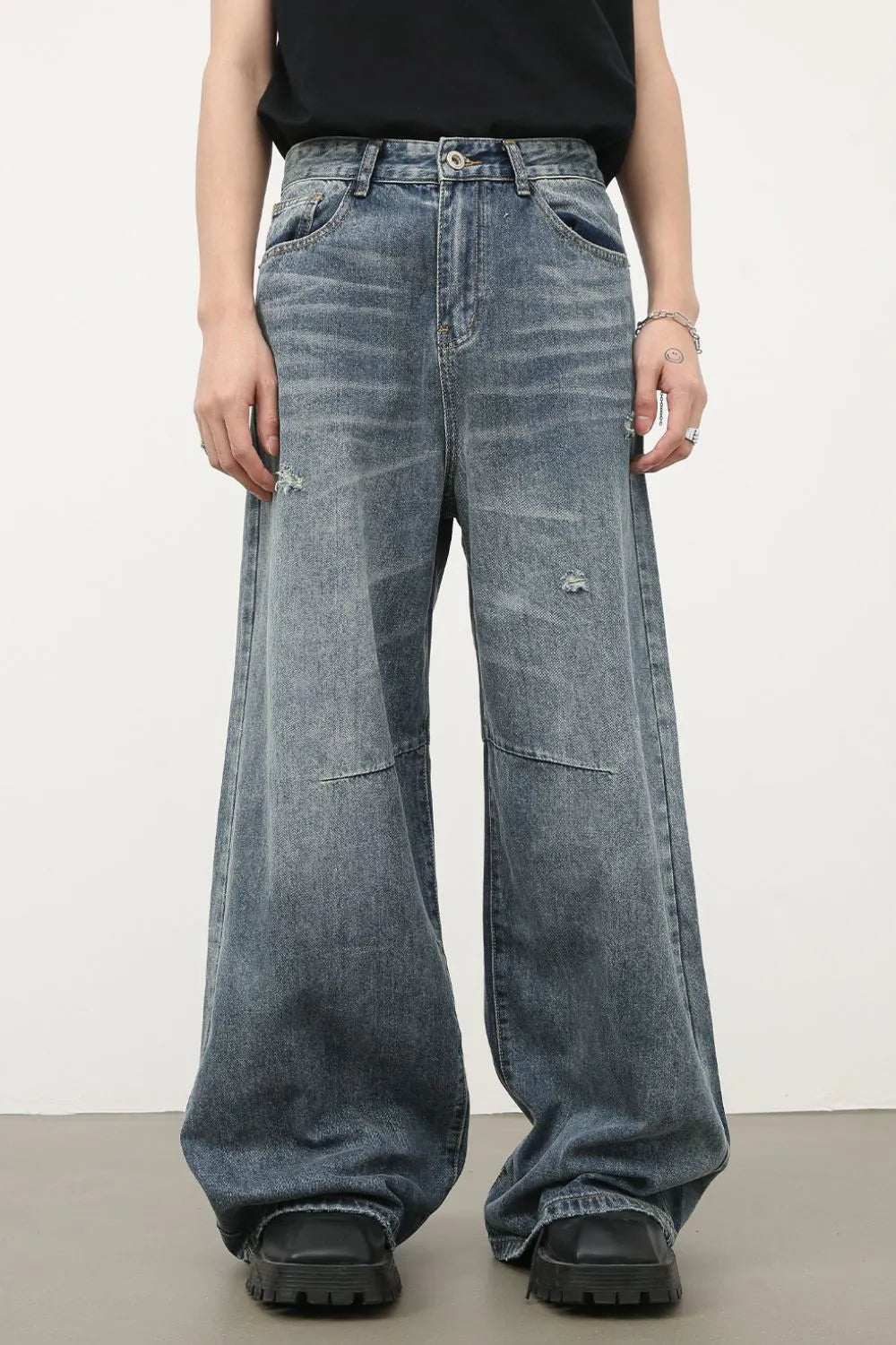 Distressed edge wide-leg jeans in medium wash denim with a relaxed fit and frayed details.