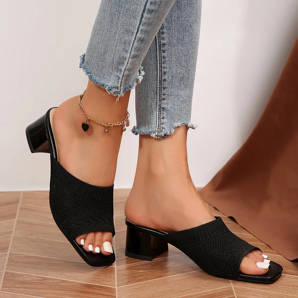 Black knit block heel mules with open toe and square toe.