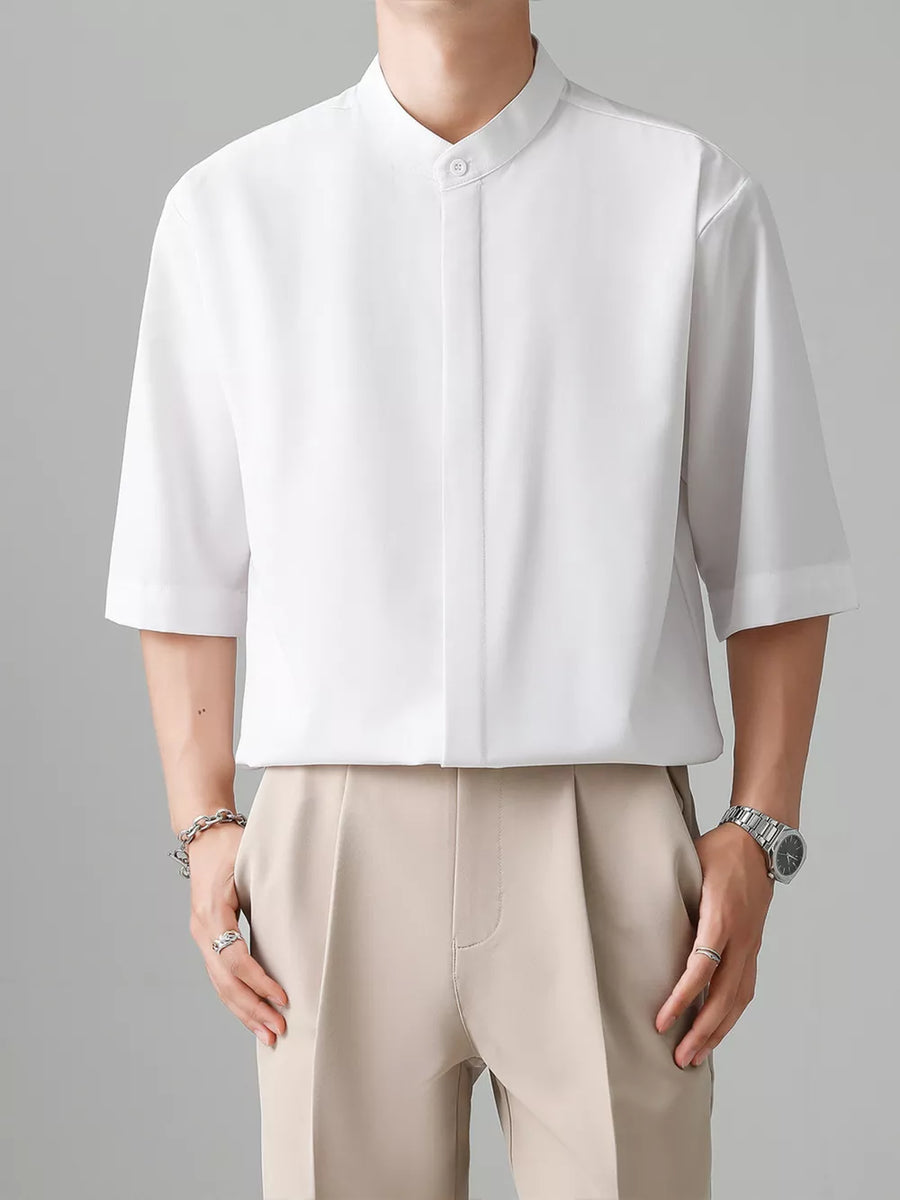 White oversized half-sleeve shirt with Mandarin collar and button detail.