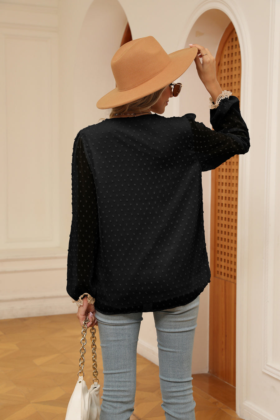 Black Swiss dot blouse with poet sleeves and lace trim cuffs.