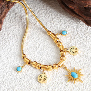 Gold celestial charm necklace with turquoise accents and tree charms