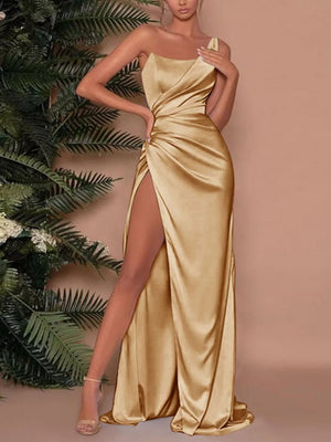Gold one-shoulder ruched maxi dress with a high slit and satin finish.
