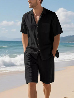 Black linen blend casual shirt and shorts ensemble on a man at the beach.