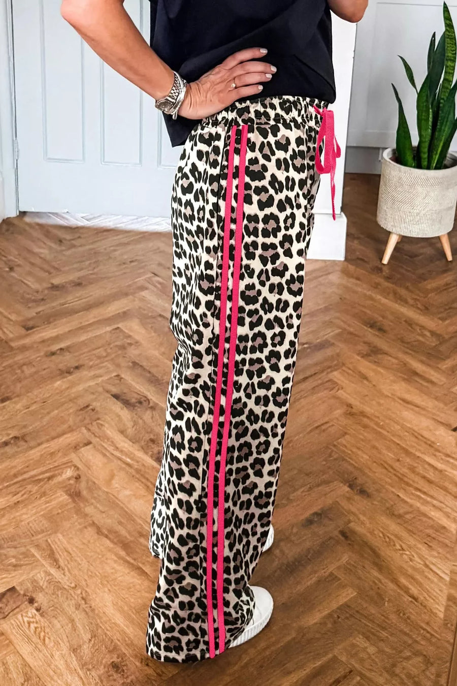 Leopard print maternity pants with pink side stripes and drawstring waist.