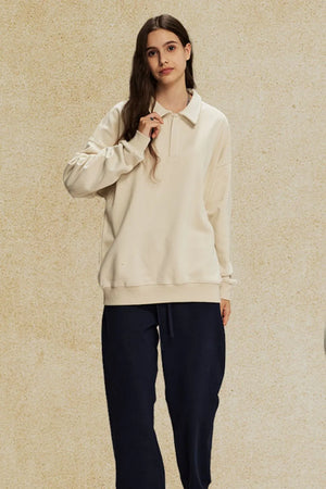 Oversized cream polo sweatshirt with collar and long sleeves, worn by a model.