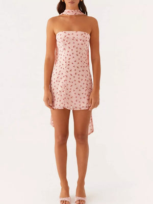 Strapless mini dress in blush pink with cherry print and a high-low hem.