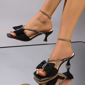 Black heeled mules with crystal bow detail and rhinestone straps