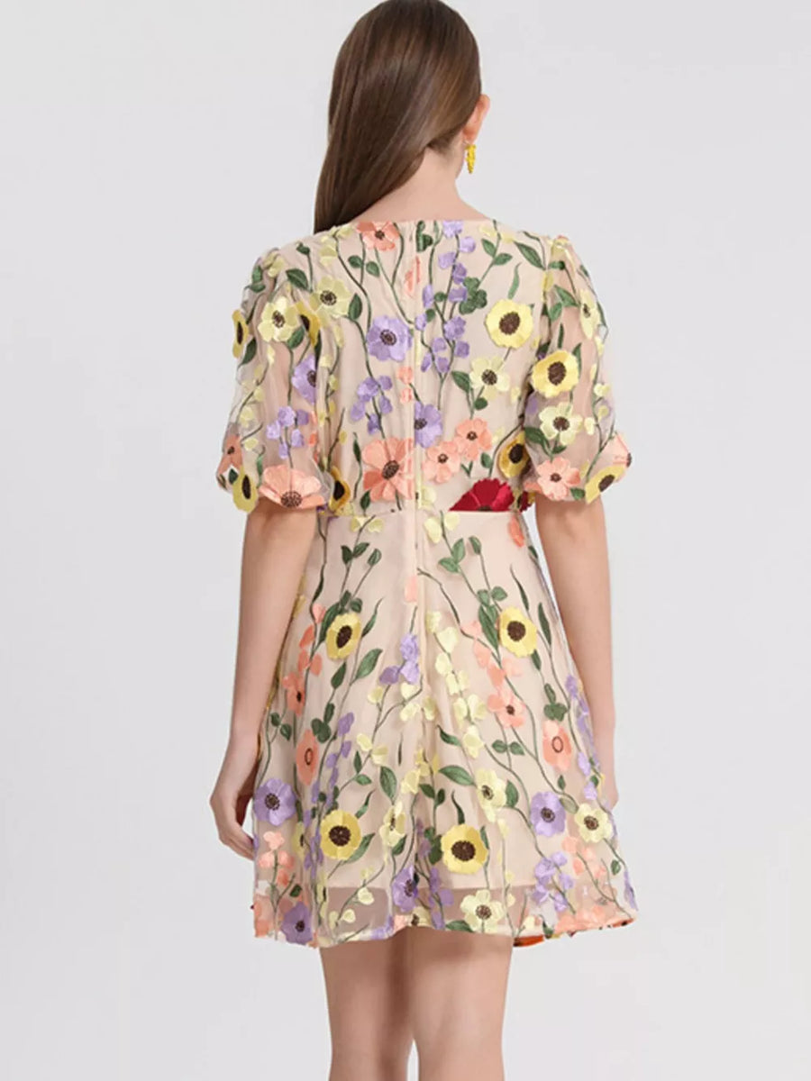 Sheer floral embroidered mini dress with puff sleeves and a round neckline.