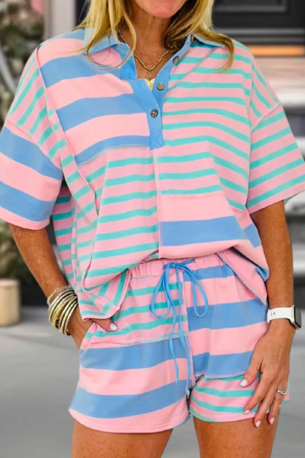 Striped pink, blue, and teal polo shirt and shorts set with drawstring shorts.