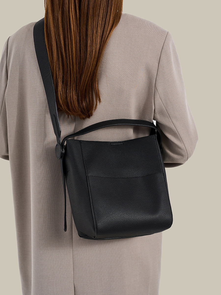 crossbody bag in black featuring textured and bucket fit
