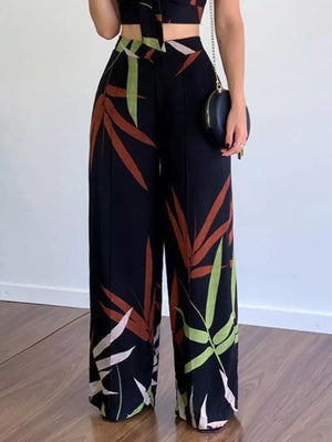 Black tropical print crop top and wide-leg pants set with V-neck and polyester fabric.