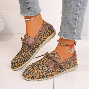 Leopard print boat shoes with brown leather trim and lace-up detail.