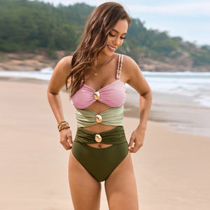 Colorblock one-piece swimsuit with gold hardware details and cutout waist in blush pink, sage green, and olive.