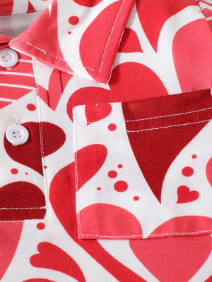 Baby polo shirt with red and pink heart print, white buttons, and chest pocket.
