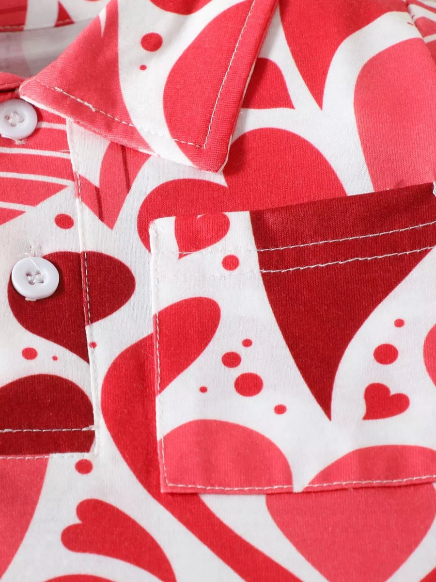 Baby polo shirt with red and pink heart print, white buttons, and chest pocket.