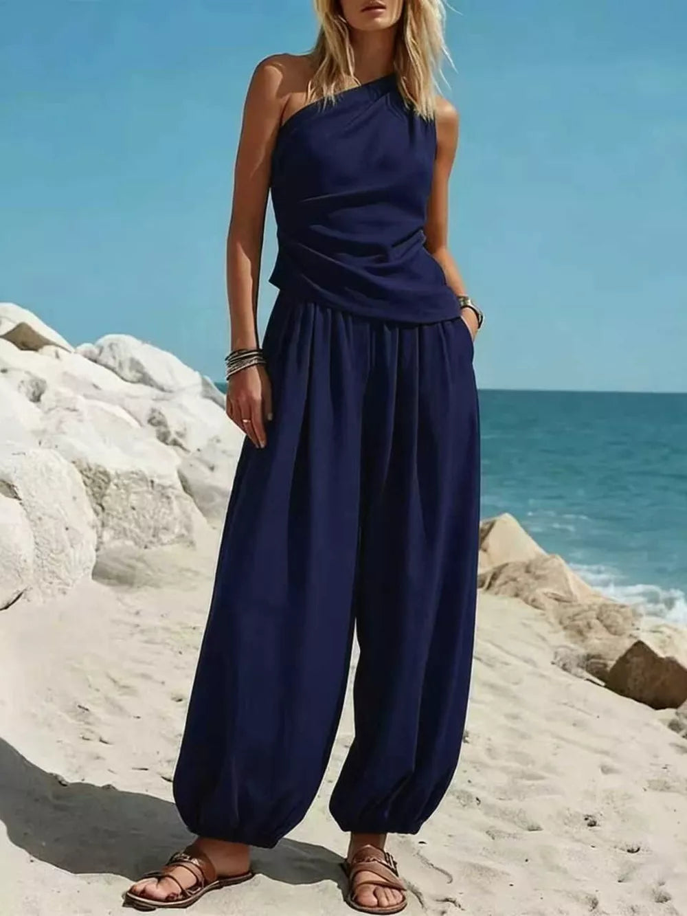 Navy blue one-shoulder jumpsuit with wide-leg pants and ruched bodice