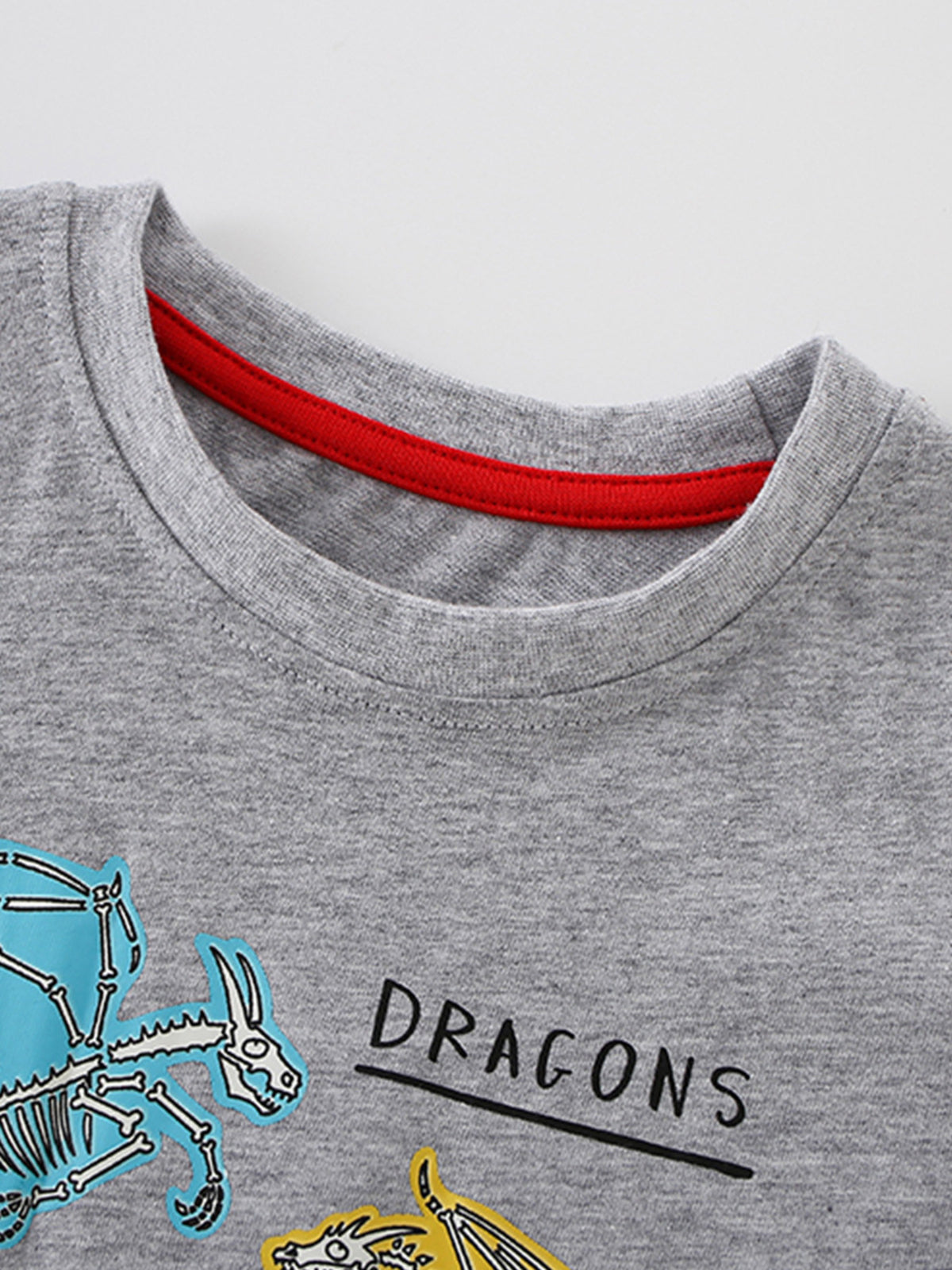 Grey cotton crew neck t-shirt with blue and yellow dragon skeleton graphics and "DRAGONS" text.