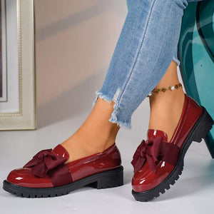Chic burgundy patent loafers with bow detail and lug sole.