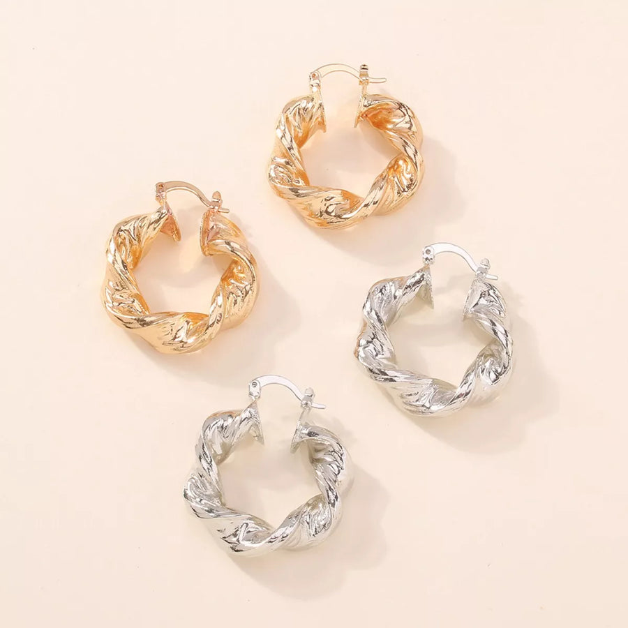 Textured hoop earrings in gold and silver with twisted design