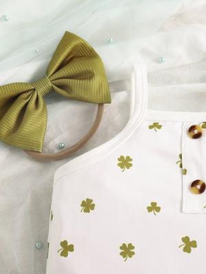 White baby bodysuit with green clover print and button detail, paired with a green bow headband.