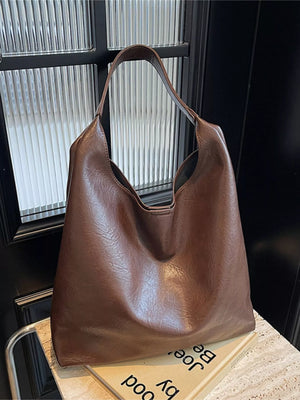 Brown PU leather tote bag with slouchy silhouette and single strap.