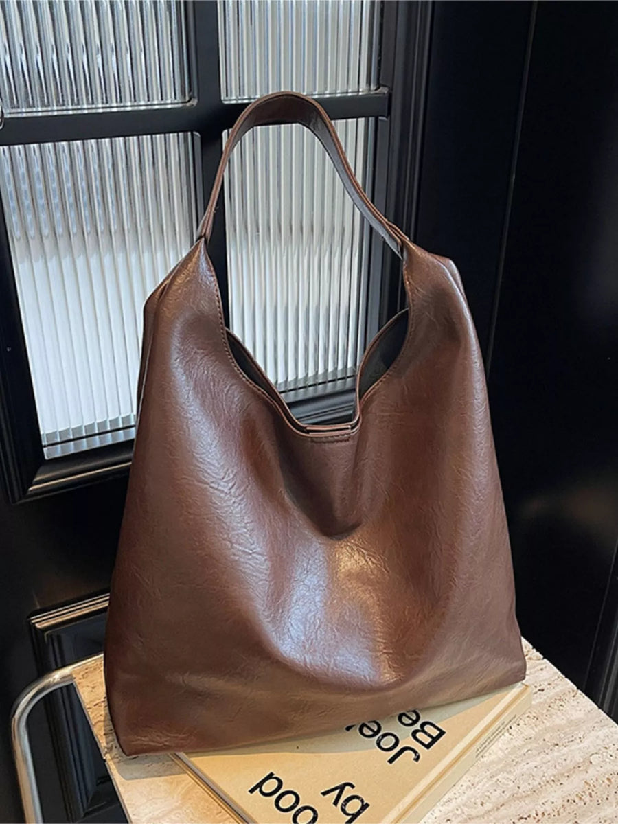 Brown PU leather tote bag with slouchy silhouette and single strap.