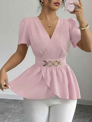 Pink surplice peplum blouse with gold chain belt and puff sleeves.