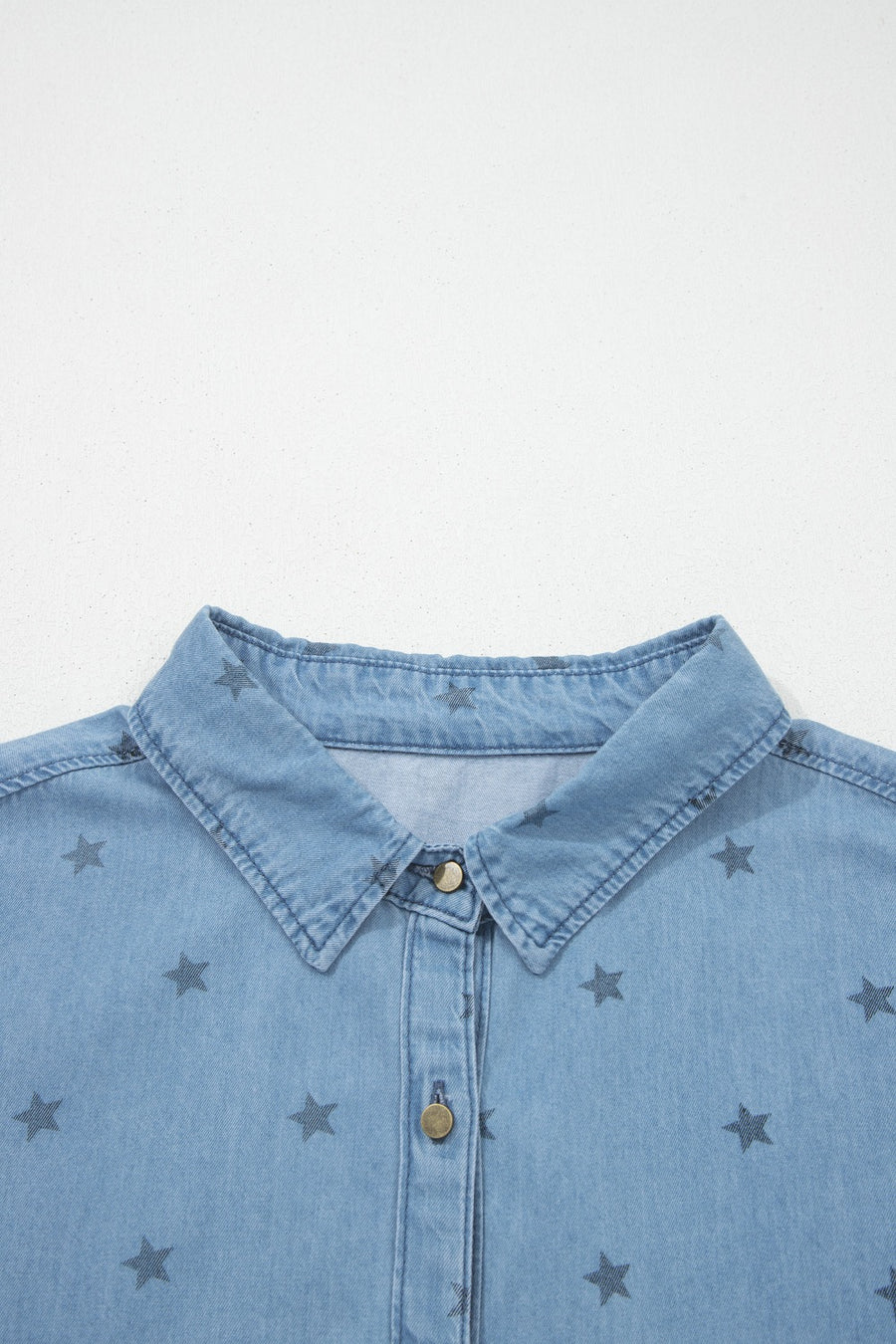 Light blue denim shirt with dark star print, button-down collar, and button front.
