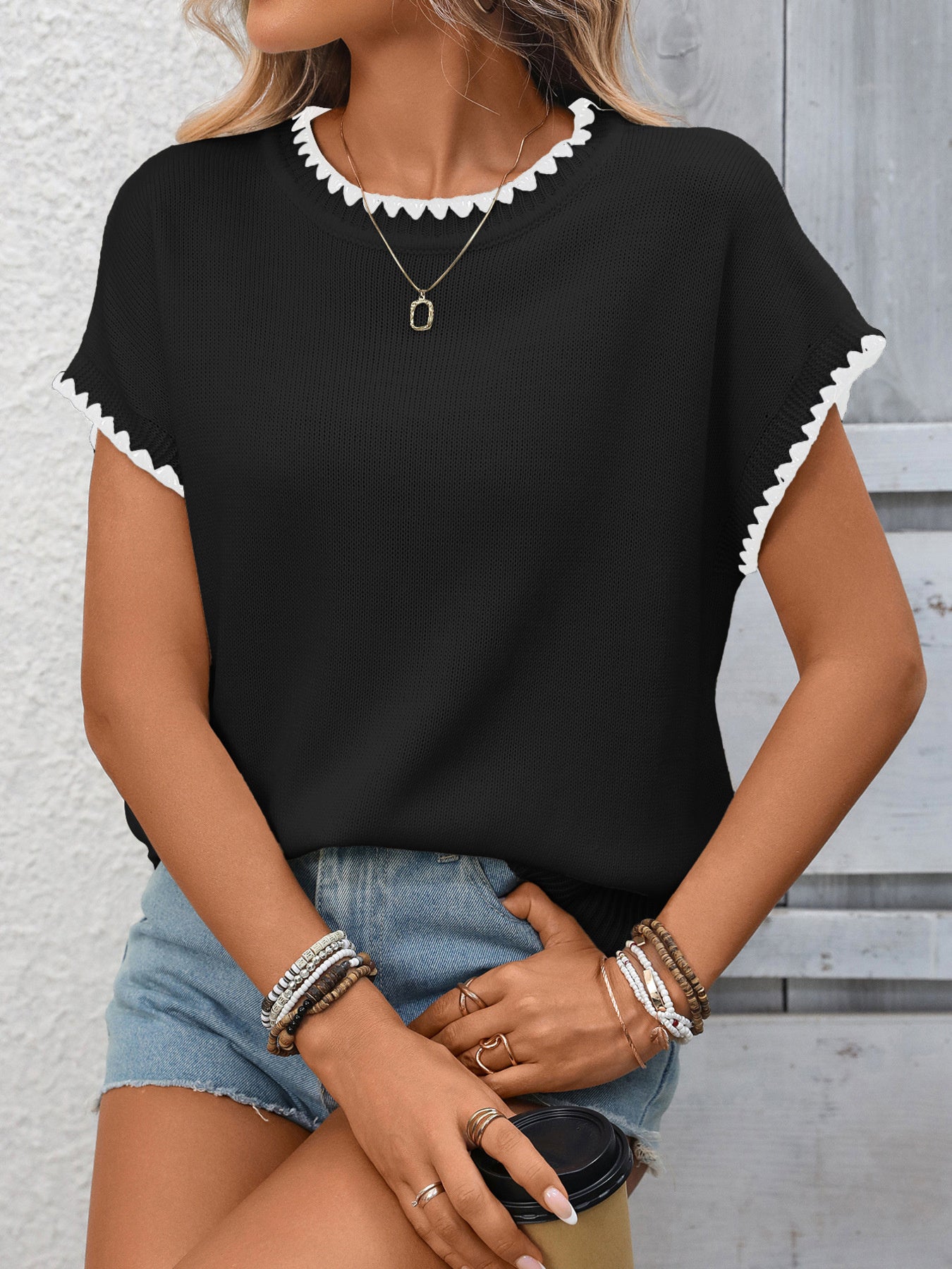 Black short-sleeve knit sweater with scalloped contrast trim neckline and sleeves
