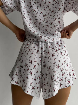 Women's white floral lounge set with relaxed top and flared shorts.