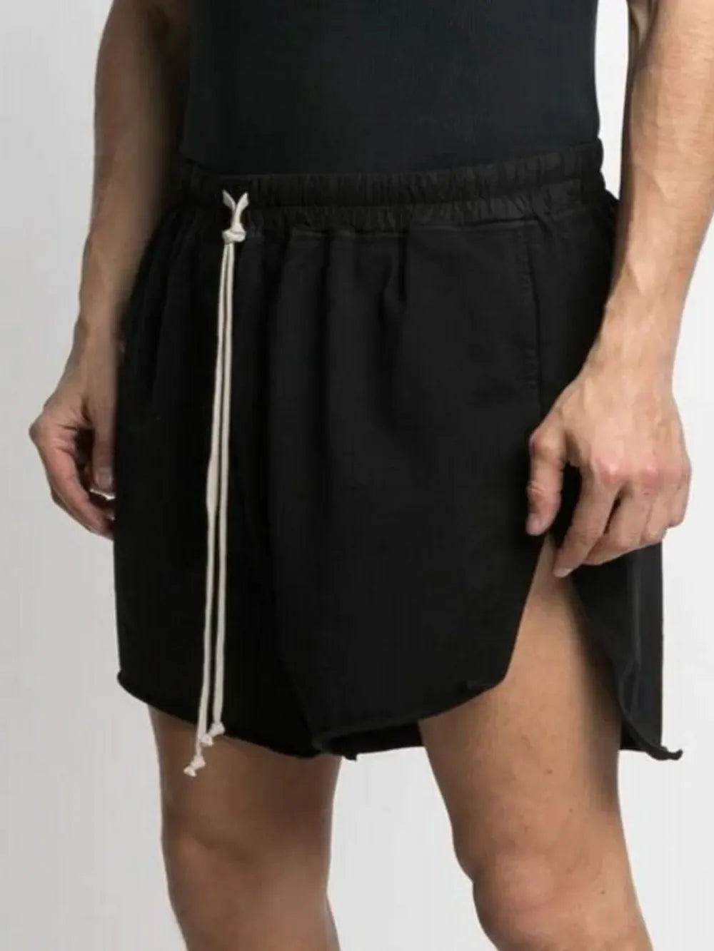 Black lounge shorts with raw hem and high slit legs, featuring a drawstring waist.