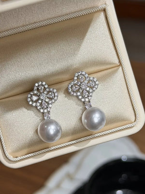 Elegant clover zircon and pearl drop earrings with a beige setting.