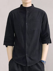 Black cotton button-down shirt with roll-up sleeves and chest pocket.