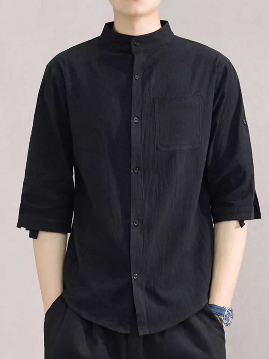 Black cotton button-down shirt with roll-up sleeves and chest pocket.