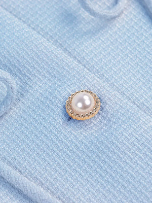 Light blue textured knit cardigan with pearl and gold button detail.