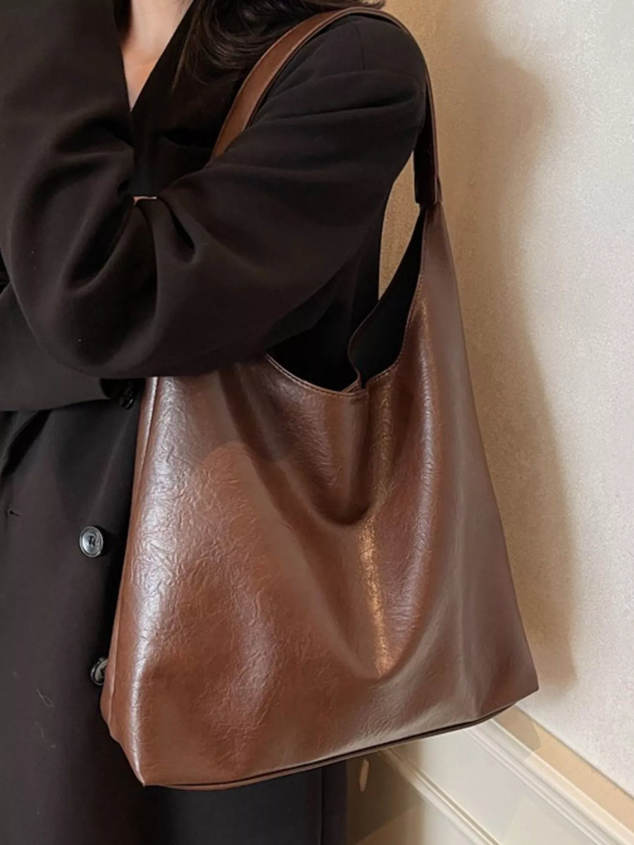 Brown PU leather tote bag with a slouchy, unstructured design and shoulder strap.