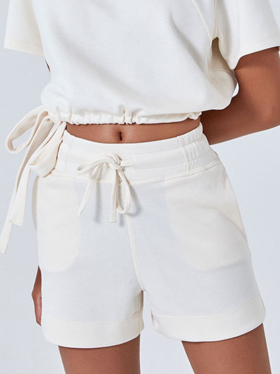 Cream drawstring pocket shorts with elastic waistband and cuffed hem